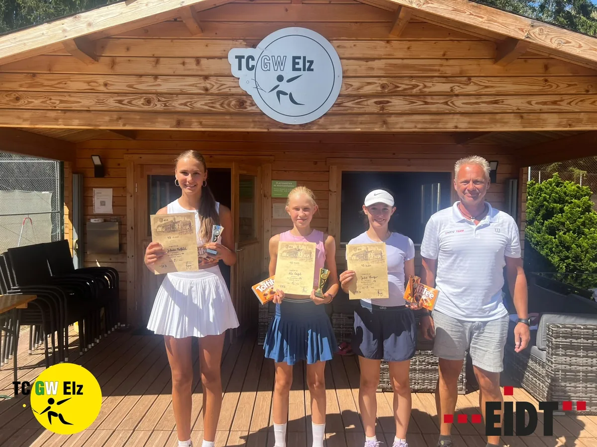 Drei junge Spielerinnen des TC Grün-Weiß Elz mit Urkunden und Pokal vor dem Clubhaus, daneben ein Vertreter des Sponsors.